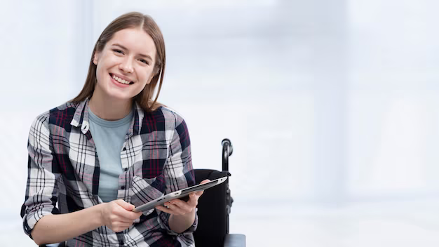 The girl holds a tablet in her hands and smiles