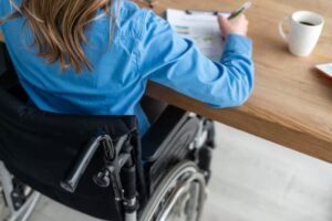 A girl in a wheelchair signing documents