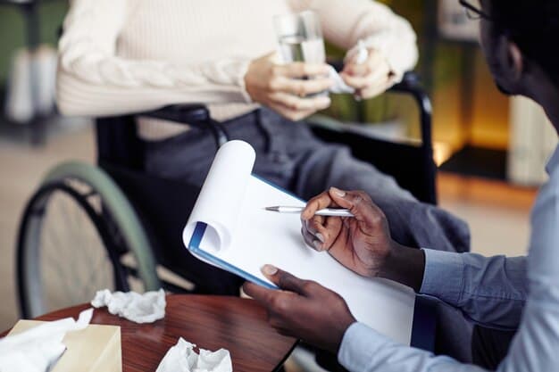 A man fills out paperwork near a man in a wheelchair