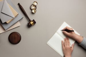 Top view of woman writing on a paper and items for judges on the table